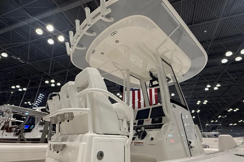 Slide: The Image of 2026 Regulator 25 boat interior with helm station and seating, showcased indoors. - 3