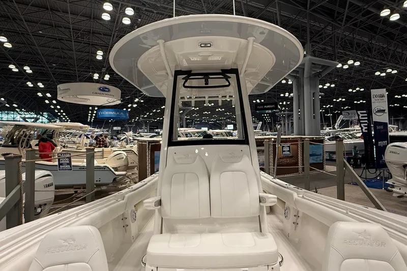 Slide: The Image of 2026 Regulator 25 boat showcased at an indoor exhibition, featuring sleek white seating and modern design. - 31