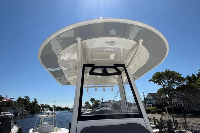 Slide: The Image of 2026 Regulator 25 boat with T-top, viewed from below, against a clear blue sky. - 32