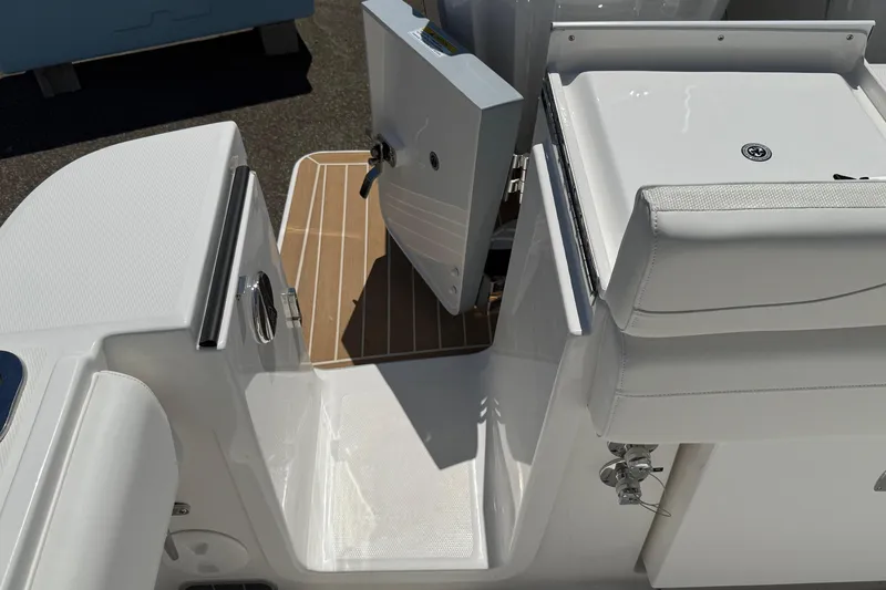 Slide: The Image of 2026 Regulator 25 boat interior with white seating and open storage compartment. - 37