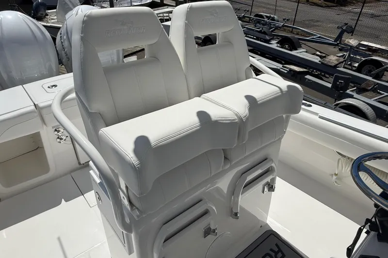 Slide: The Image of 2026 Regulator 25 boat with white cushioned seats and steering wheel. - 48