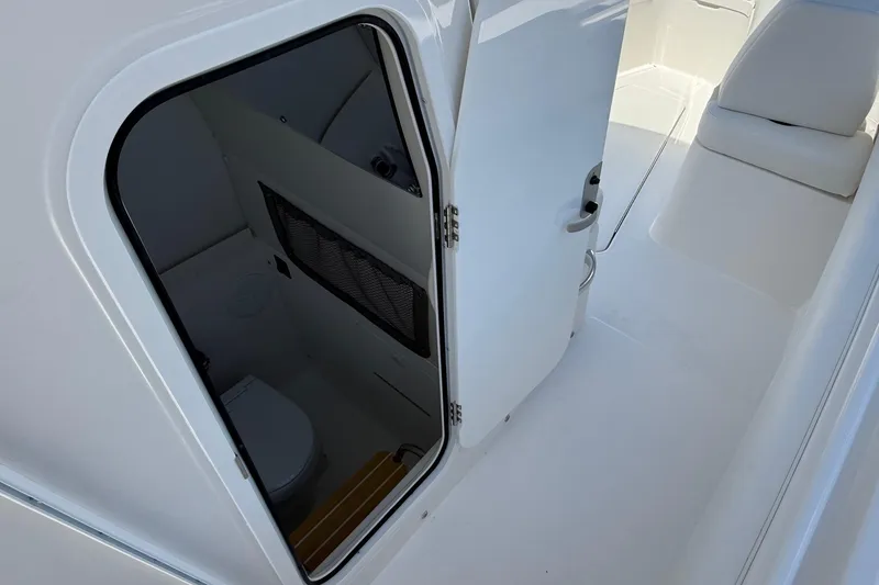 Slide: The Image of 2026 Regulator 25 boat interior with open door revealing compact restroom. - 59