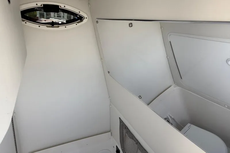 Slide: The Image of Interior cabin of 2026 Regulator 25 boat, featuring sleek white design and storage compartments. - 61