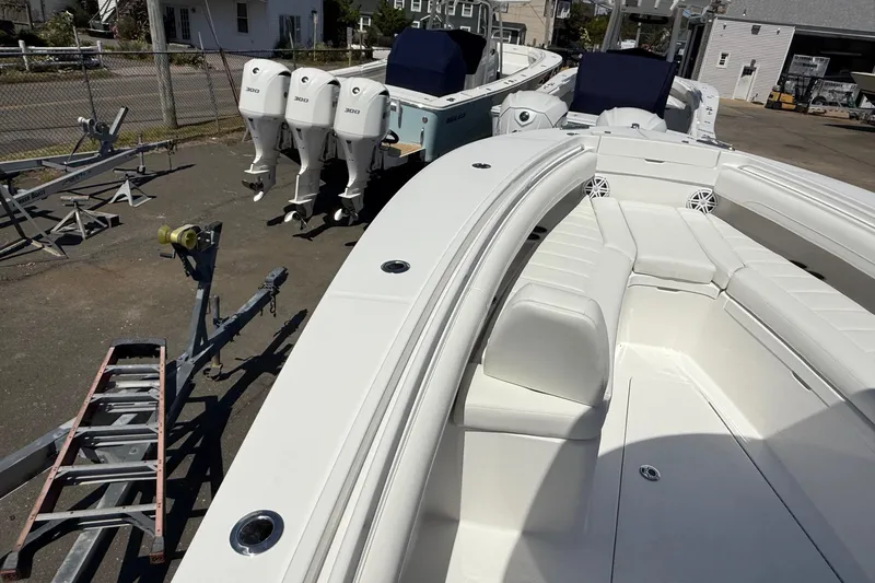 Slide: The Image of 2026 Regulator 25 boat with triple engines, docked outdoors, showcasing sleek design and seating. - 65