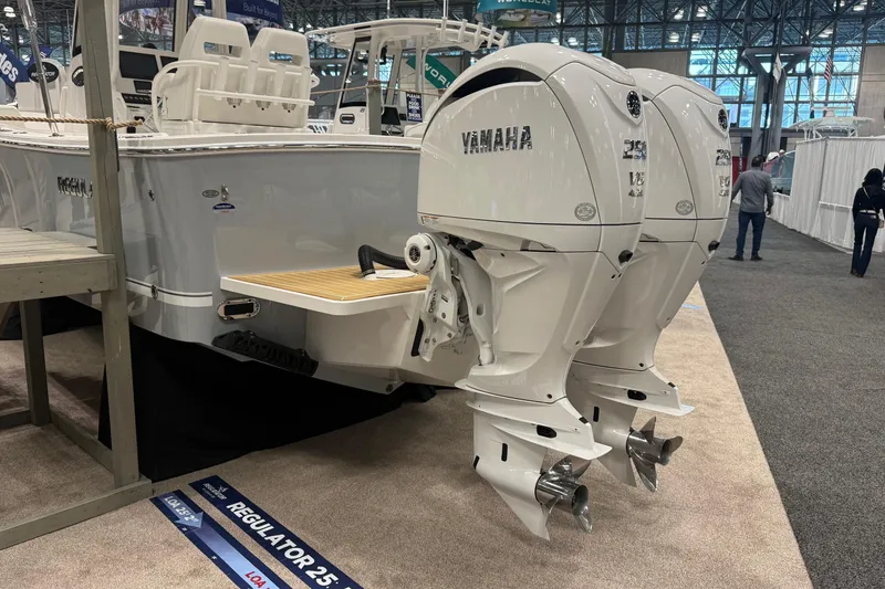 Slide: The Image of 2026 Regulator 25 boat with twin Yamaha outboard engines displayed at a boat show. - 7