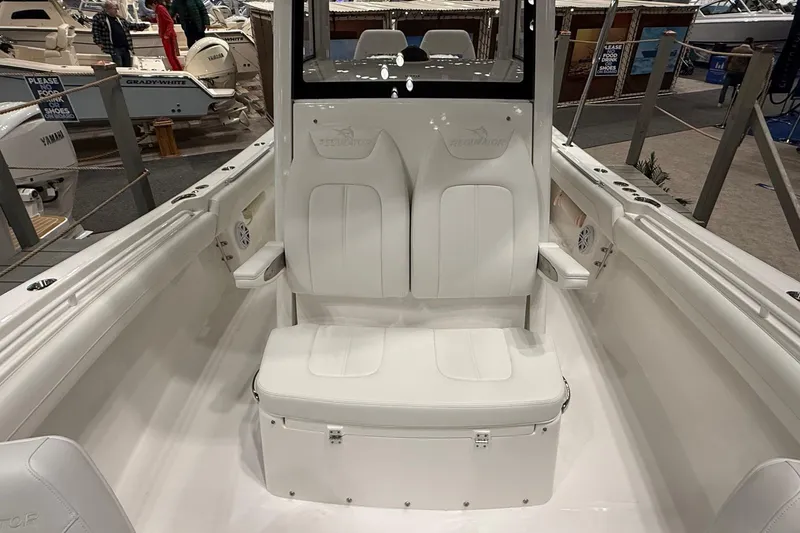 Slide: The Image of 2026 Regulator 25 boat interior with white seating at a boat show. - 74