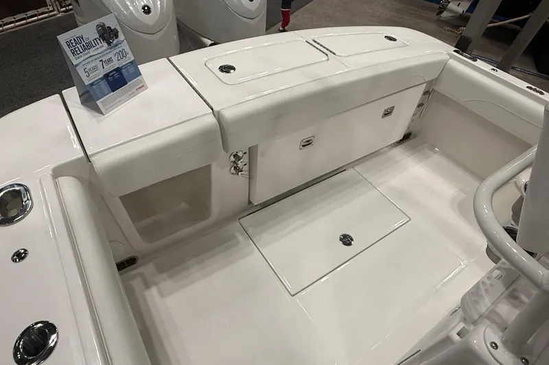 Slide: The Image of 2026 Regulator 25 boat interior with white seating and storage compartments. - 82