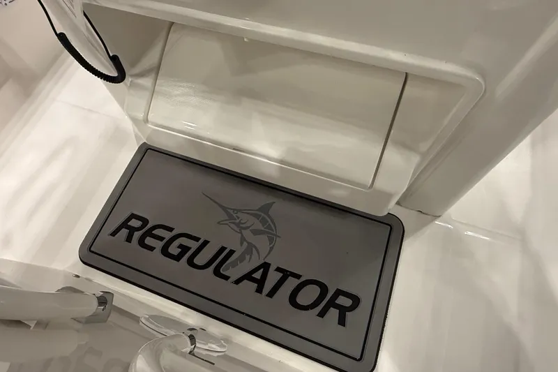 Slide: The Image of 2026 Regulator 25 boat interior with branded mat and storage compartment. - 84