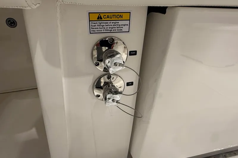 Slide: The Image of 2026 Regulator 25 boat engine flush fittings with caution label. - 88