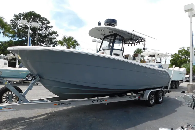Slide: The Image of 2021 Cobia 262 Center Console boat on trailer, displayed outdoors. - 1