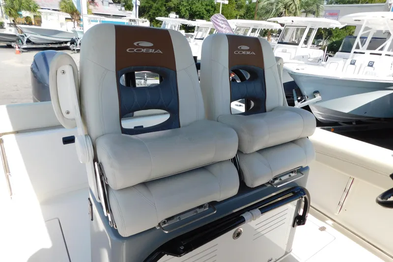 Slide: The Image of 2021 Cobia 262 Center Console boat seats, featuring dual cushioned chairs with armrests. - 14