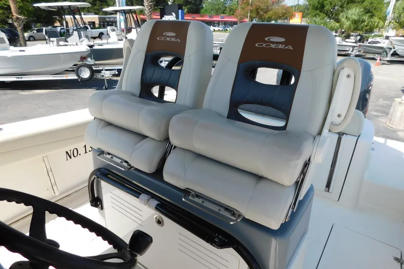 Slide: The Image of 2021 Cobia 262 Center Console boat with dual cushioned seats and steering wheel. - 15