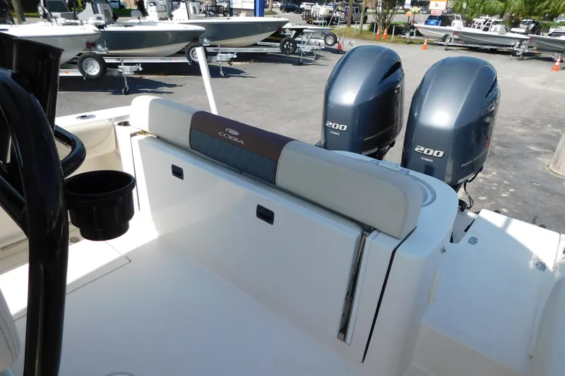 Slide: The Image of 2021 Cobia 262 Center Console boat with dual Yamaha 200 engines, docked outdoors. - 16