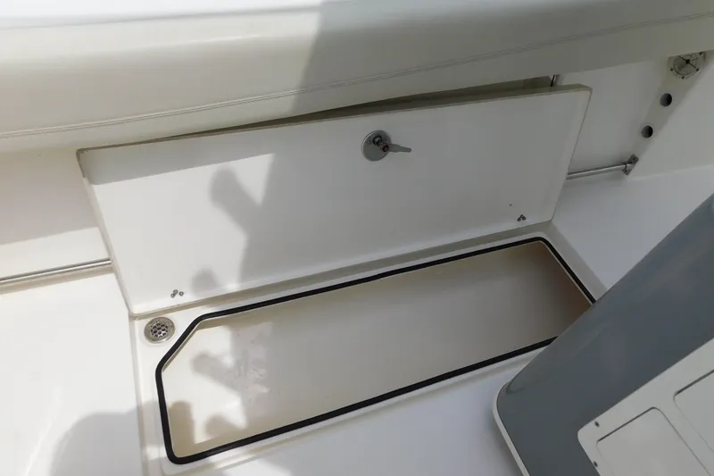 Slide: The Image of 2021 Cobia 262 Center Console boat storage compartment with drain and secure latch. - 19