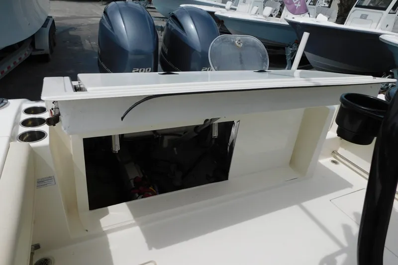 Slide: The Image of 2021 Cobia 262 Center Console boat with dual Yamaha 200 engines, open storage compartment. - 21