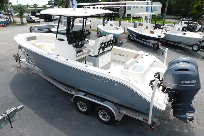 Slide: The Image of 2021 Cobia 262 Center Console boat with Yamaha engines on a trailer in a marina. - 22