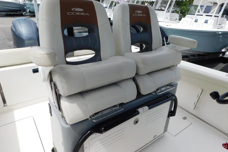 Slide: The Image of 2021 Cobia 262 Center Console boat with dual cushioned seats and armrests. - 30