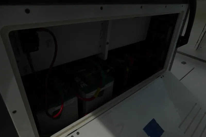 Slide: The Image of 2021 Cobia 262 Center Console battery compartment with wiring and connections. - 31