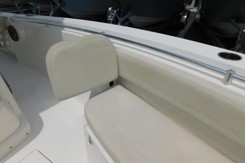 Slide: The Image of 2021 Cobia 262 Center Console boat interior seating with cup holder and railing. - 38