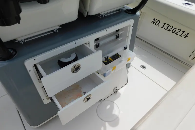 Slide: The Image of 2021 Cobia 262 Center Console boat with open storage compartments and visible registration number. - 44