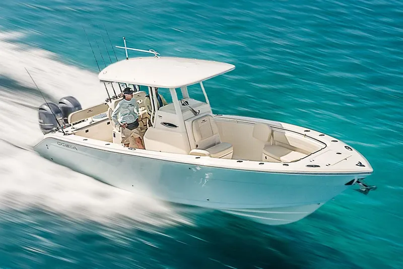 Slide: The Image of Manufacturer Provided Image: 2021 Cobia 262 Center Console boat cruising on clear blue water. - 45