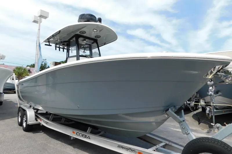 Slide: The Image of 2021 Cobia 262 Center Console boat on trailer, displayed outdoors under blue sky. - 5