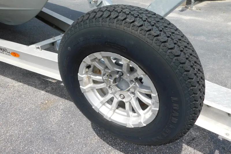 Slide: The Image of Trailer wheel of a 2021 Cobia 262 Center Console boat on pavement. - 51