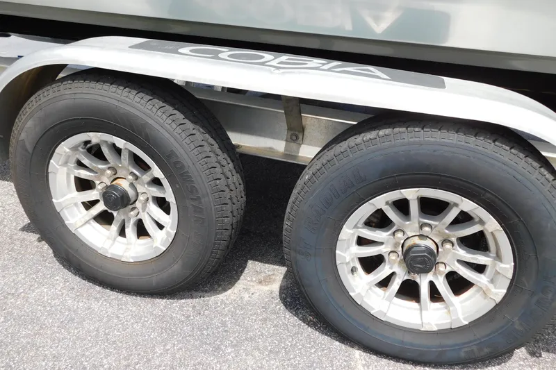 Slide: The Image of Trailer wheels of a 2021 Cobia 262 Center Console boat on pavement. - 53