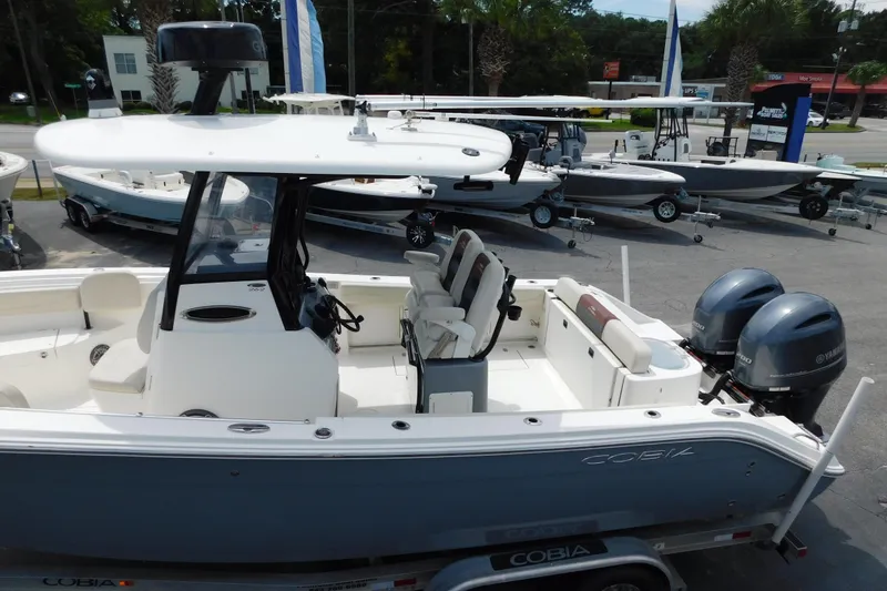 Slide: The Image of 2021 Cobia 262 Center Console boat with dual Yamaha engines, displayed at a dealership. - 7