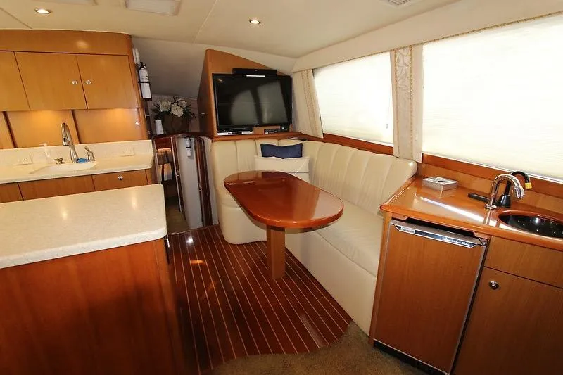 Slide: The Image of Luxurious 2002 Ocean Yachts interior with kitchenette, dining area, and entertainment system. - 14