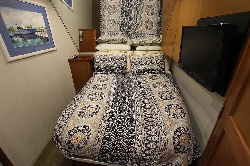 Slide: The Image of Cozy bedroom in 2002 Ocean Yachts model with patterned bedding and wall-mounted TV. - 16