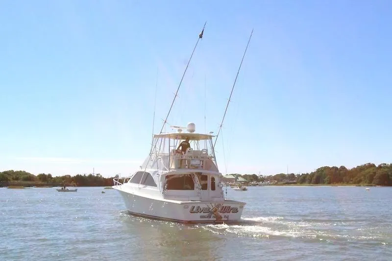 Slide: The Image of 2002 Ocean Yachts boat cruising on a sunny day, surrounded by calm waters and distant shoreline. - 3