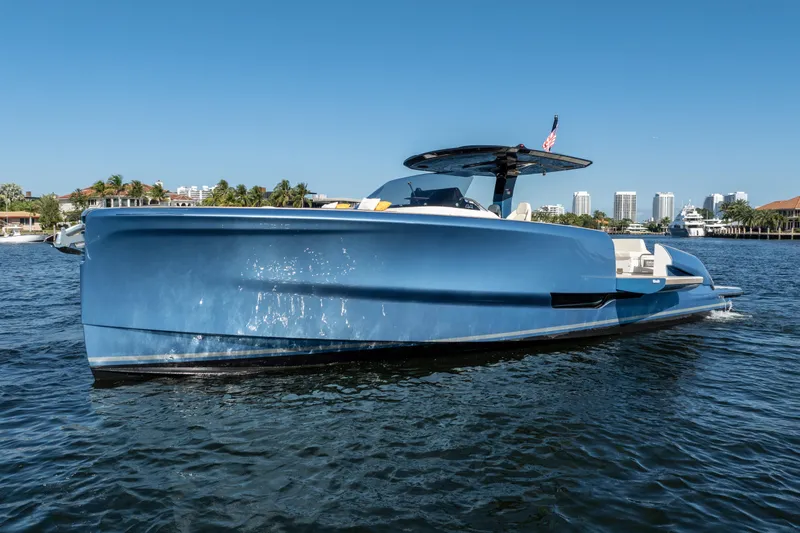 Slide: The Image of 2025 Solaris Power 44 Open yacht on water, sleek blue design, cityscape background. - 12