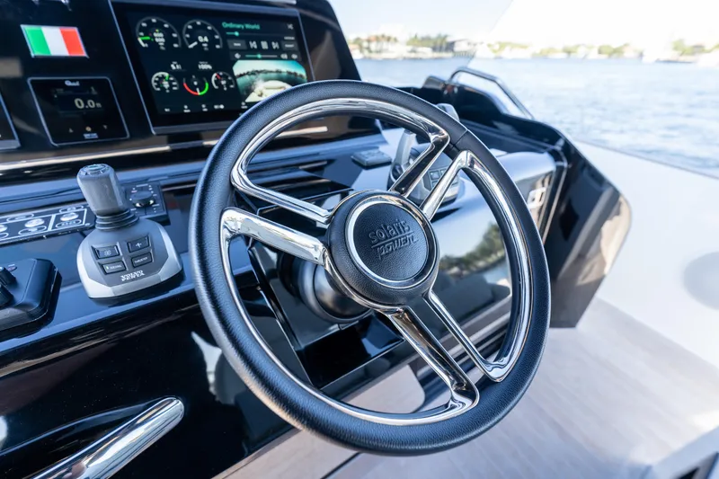 Slide: The Image of Steering wheel of 2025 Solaris Power 44 Open yacht with control panel and water view. - 56