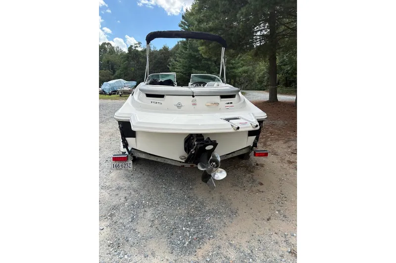 Slide: The Image of 2008 Sea Ray 195 Sport boat, rear view, parked on gravel with trees in background. - 7
