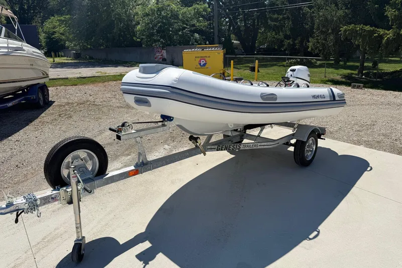 Slide: The Image of 2024 Highfield Classic 340 inflatable boat on trailer, parked outdoors. - 3