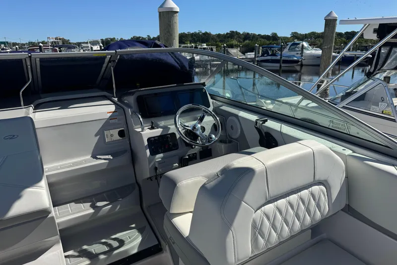 Slide: The Image of 2024 Regal 26 XO boat interior with steering wheel and dashboard at marina. - 10