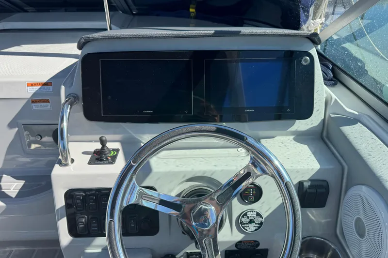 Slide: The Image of 2024 Regal 26 XO boat dashboard with dual Garmin displays and steering wheel. - 12