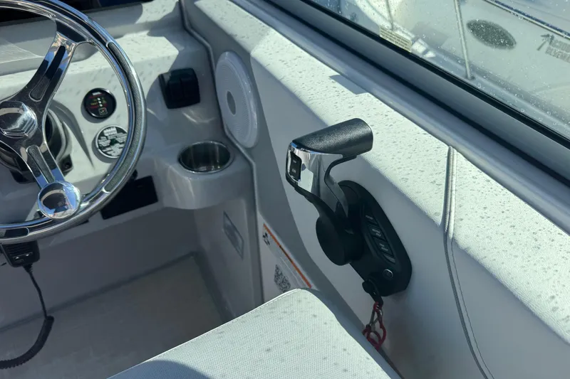 Slide: The Image of 2024 Regal 26 XO boat cockpit with steering wheel and throttle controls. - 13