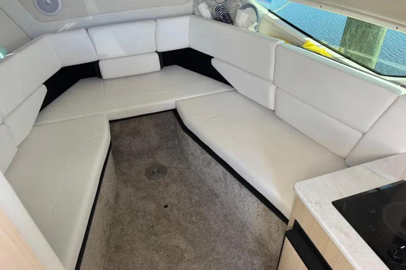 Slide: The Image of 2024 Regal 26 XO boat interior with white seating and carpeted floor. - 16