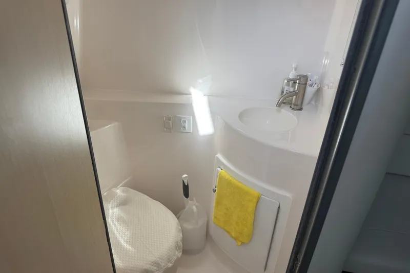 Slide: The Image of 2024 Regal 26 XO boat bathroom with sink, toilet, and yellow towel. - 17