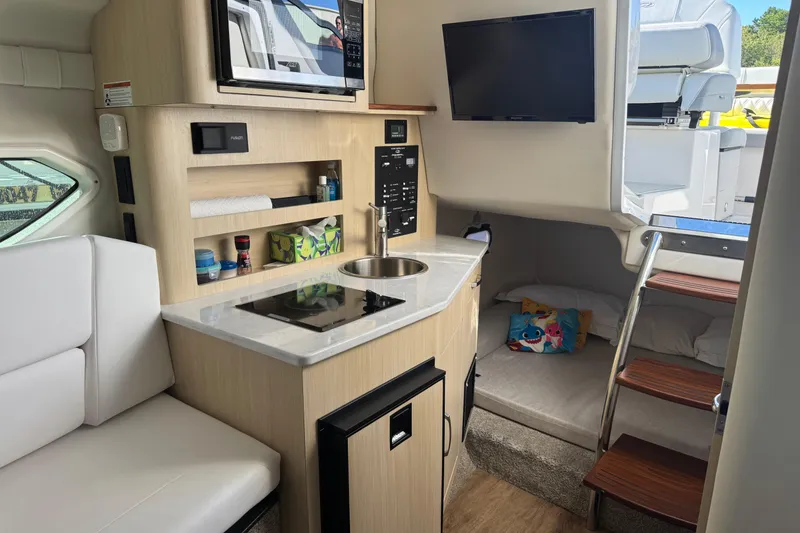 Slide: The Image of 2024 Regal 26 XO boat interior with kitchenette, seating, and sleeping area. - 18