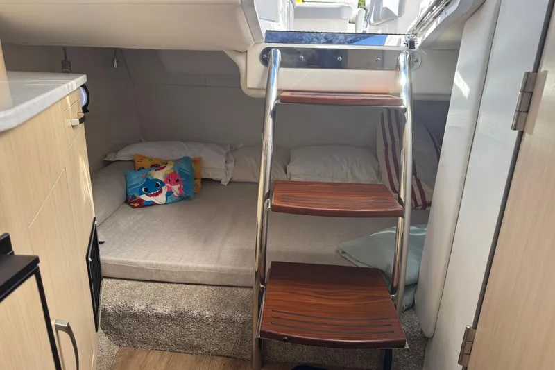 Slide: The Image of 2024 Regal 26 XO cabin interior with cozy bedding and wooden steps. - 19