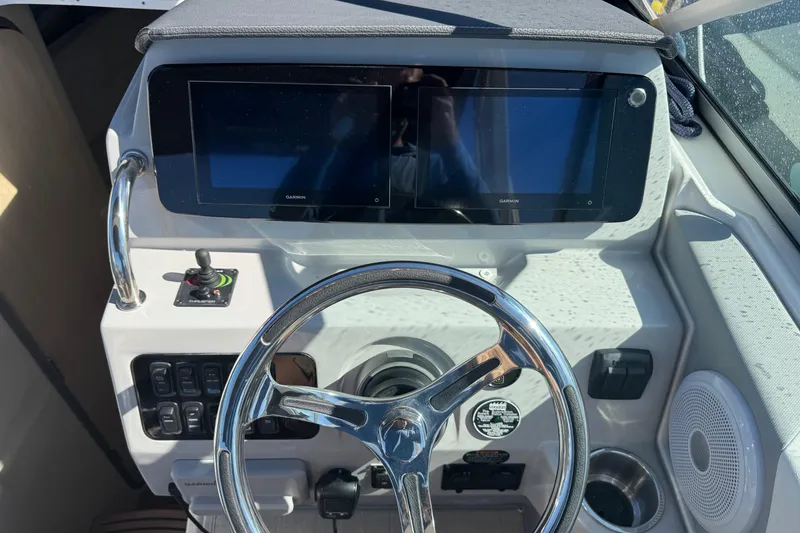 Slide: The Image of 2024 Regal 26 XO boat dashboard with dual Garmin displays and steering wheel. - 22