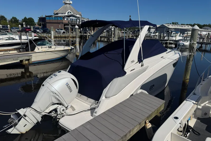 Slide: The Image of 2024 Regal 26 XO boat docked with Yamaha outboard engine, covered in navy blue. - 4
