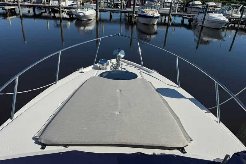 Slide: The Image of 2024 Regal 26 XO boat docked at marina, featuring spacious bow with sunpad. - 6