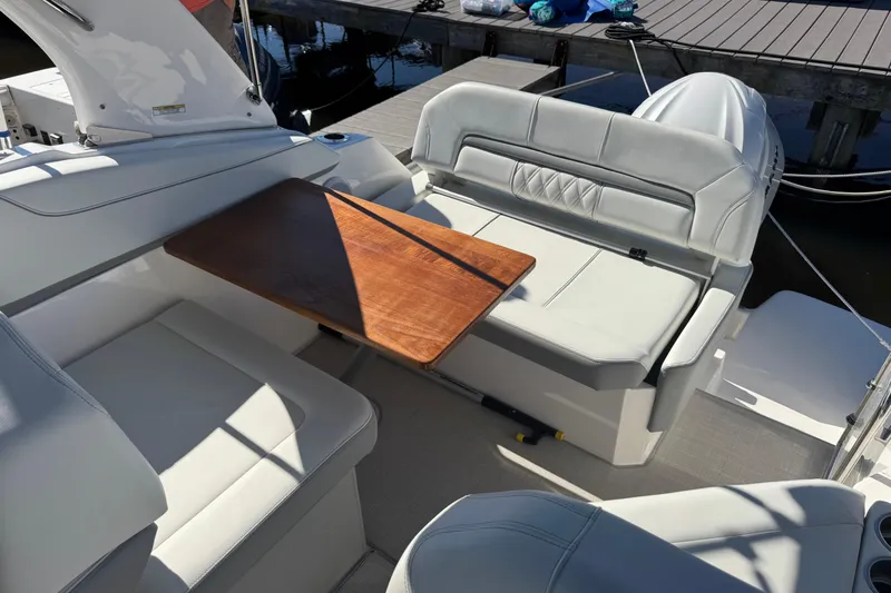 Slide: The Image of 2024 Regal 26 XO boat interior with white seating and wooden table. - 7