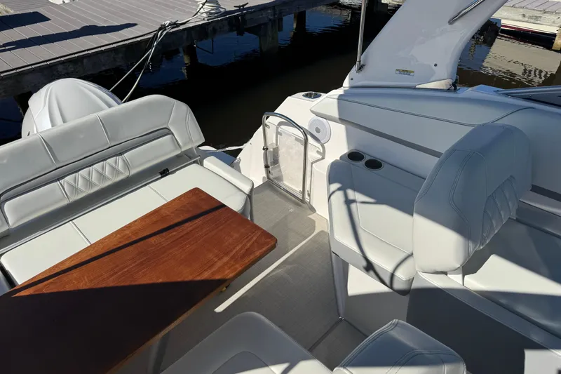 Slide: The Image of 2024 Regal 26 XO boat interior with white seating and wooden table. - 9