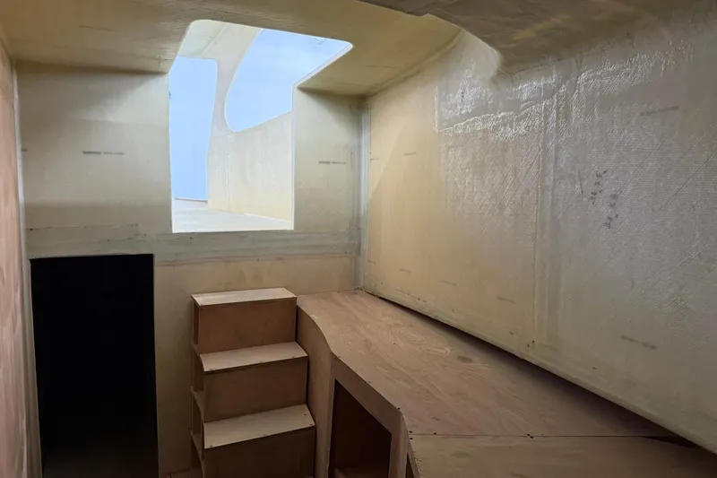 Slide: The Image of Interior of 2025 Xcelerator Walk Around boat, featuring unfinished wooden steps and open ceiling. - 12