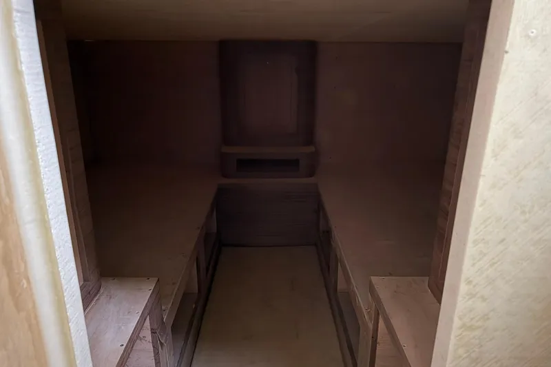 Slide: The Image of Interior of 2025 Xcelerator Walk Around boat, unfinished wooden cabin space. - 14